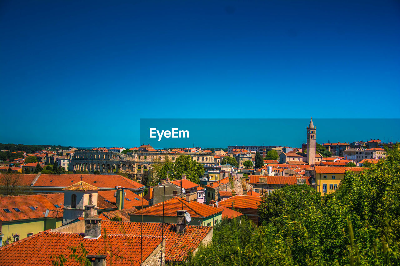 HIGH ANGLE SHOT OF TOWNSCAPE AGAINST BLUE SKY