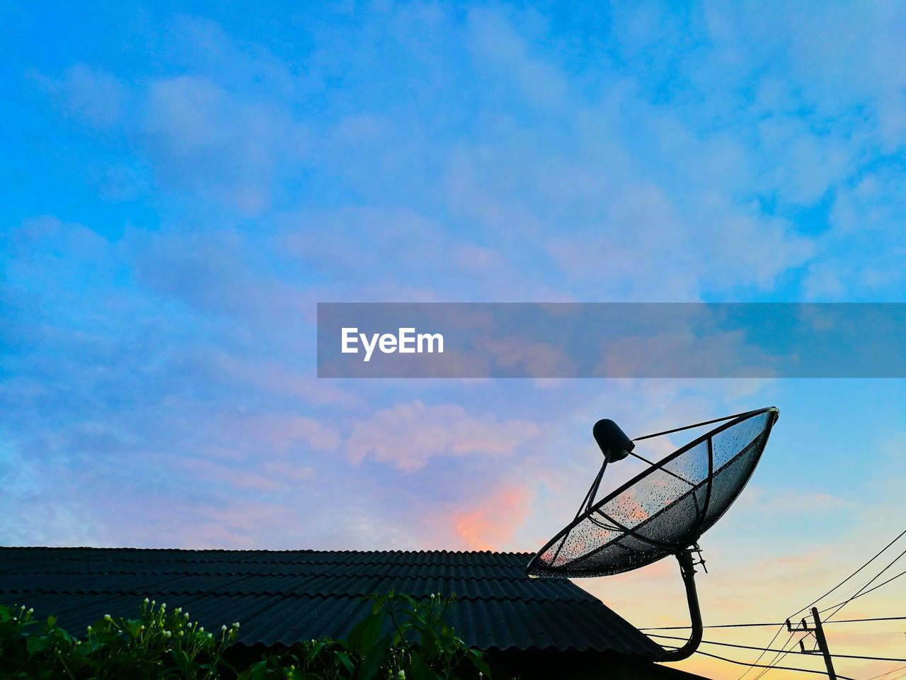 Low angle view of satellite dish on roof against sky