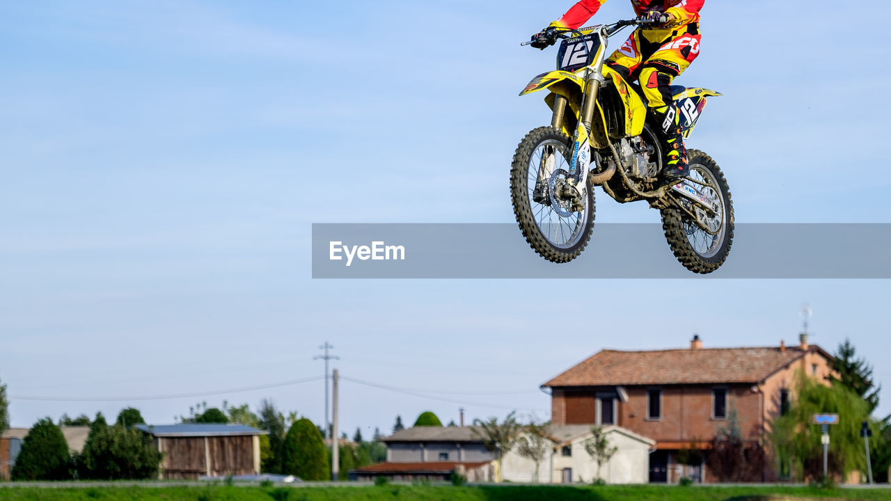 Low section of man performing motorcycle stunt in mid-air