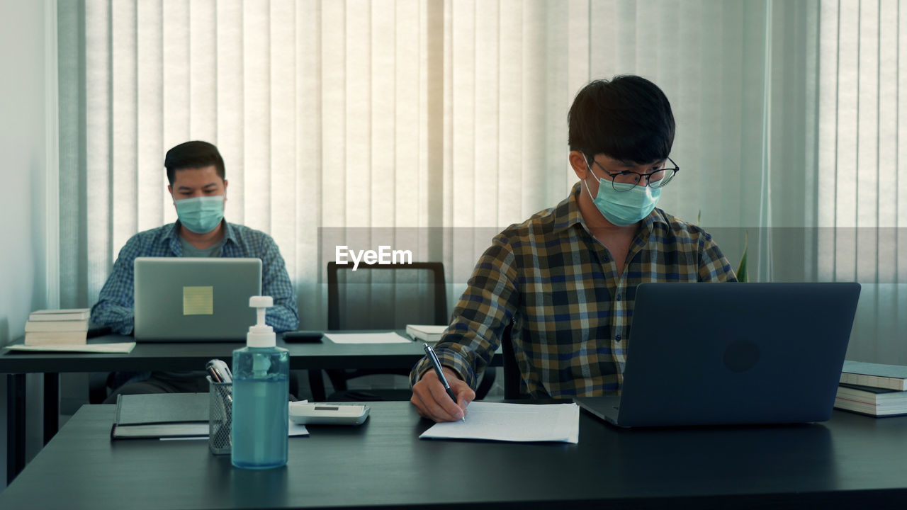 Businessmen wearing mask working in office