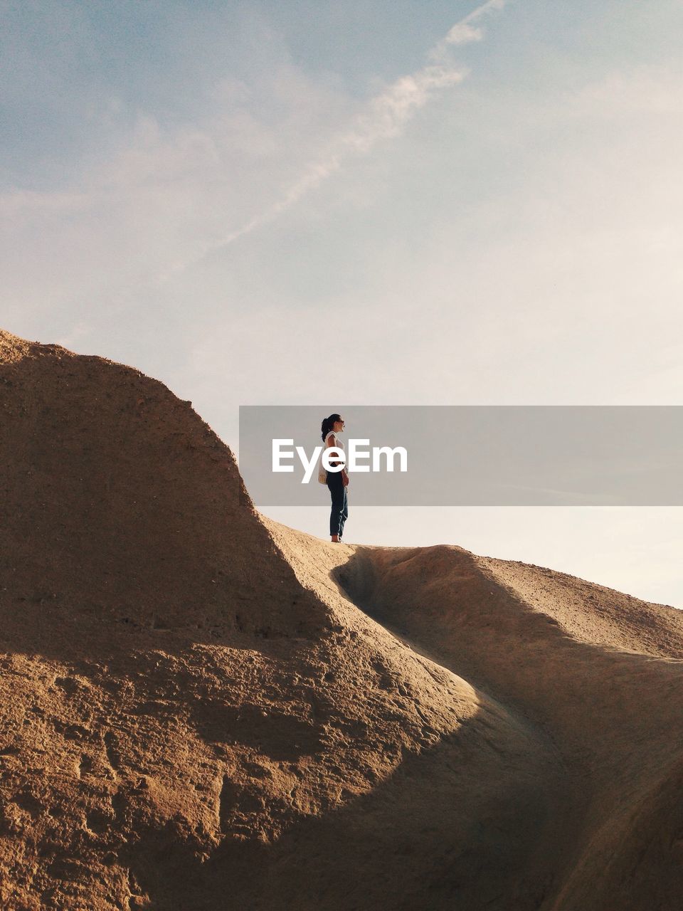 MAN STANDING ON SAND DUNE