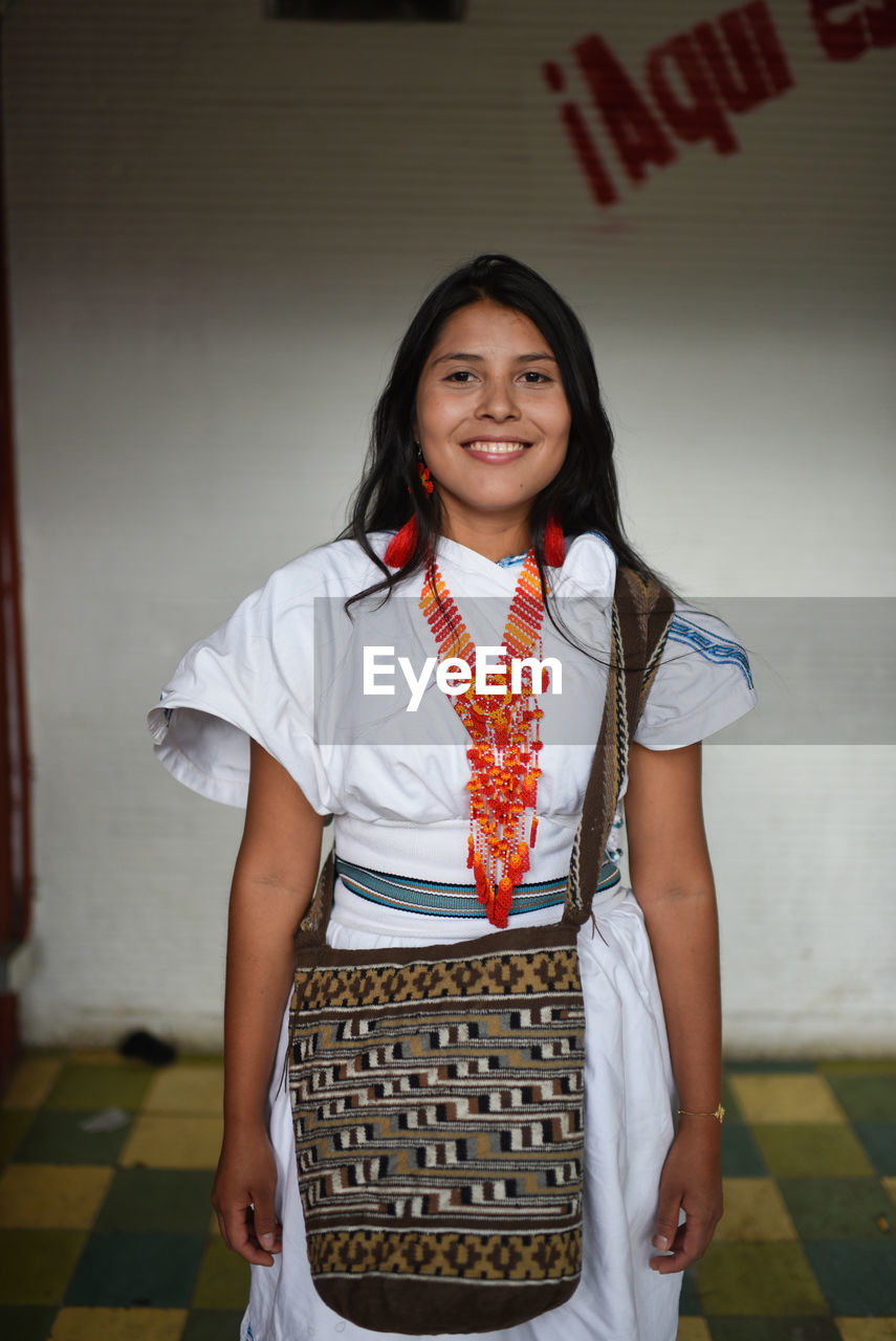 Portrait of happy young arhuaco indigenous woman in a urban environment, colombia