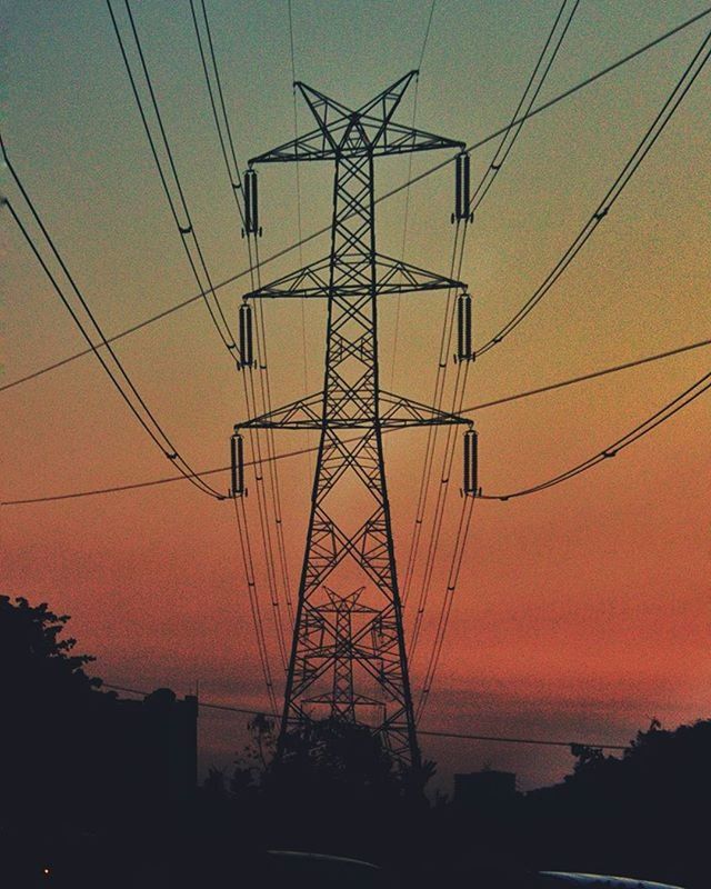 LOW ANGLE VIEW OF ELECTRICITY PYLON AT SUNSET