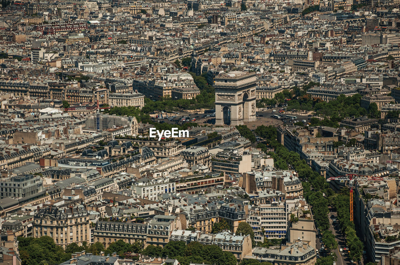 The arc de triomphe and roofs seen from the eiffel tower top in paris. the famous capital of france.