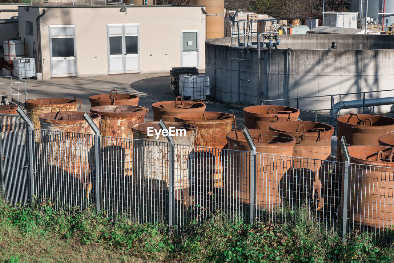 Group of rusty industrial cylindrical containers grouped outdoors.