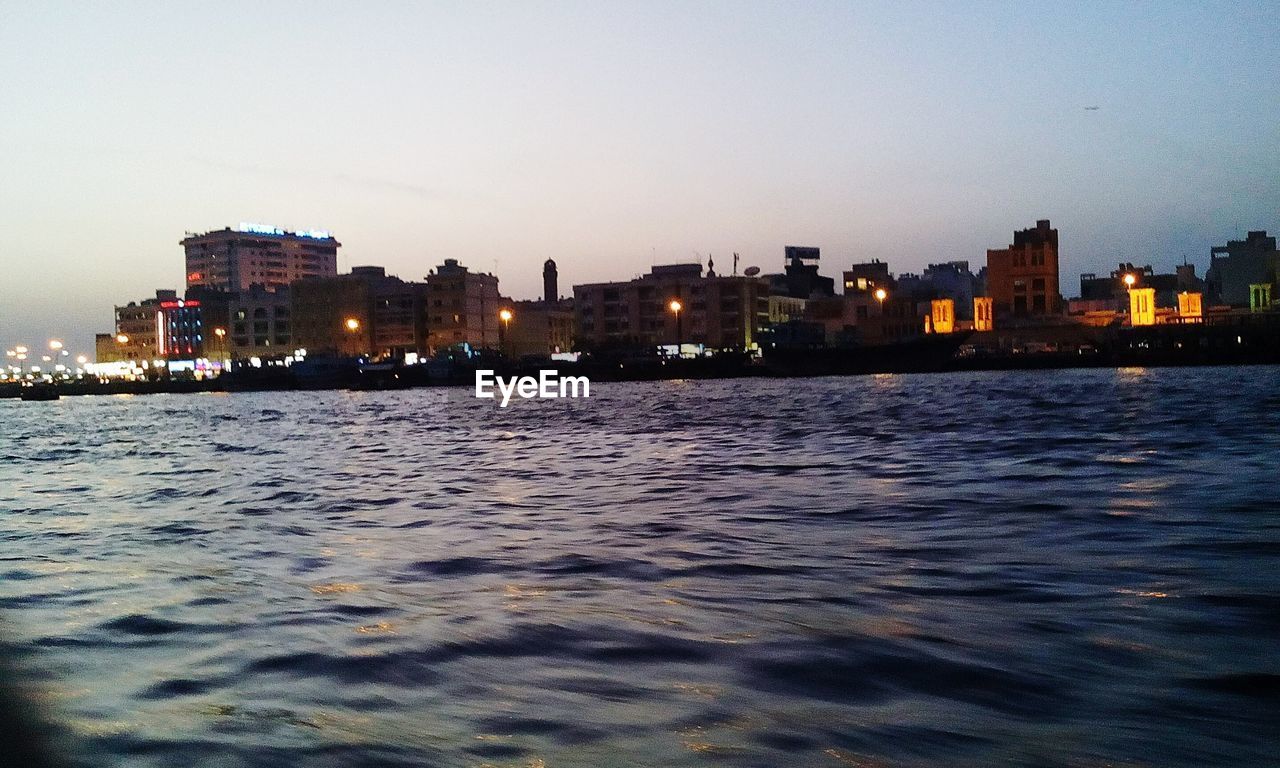 View of buildings at waterfront at dusk