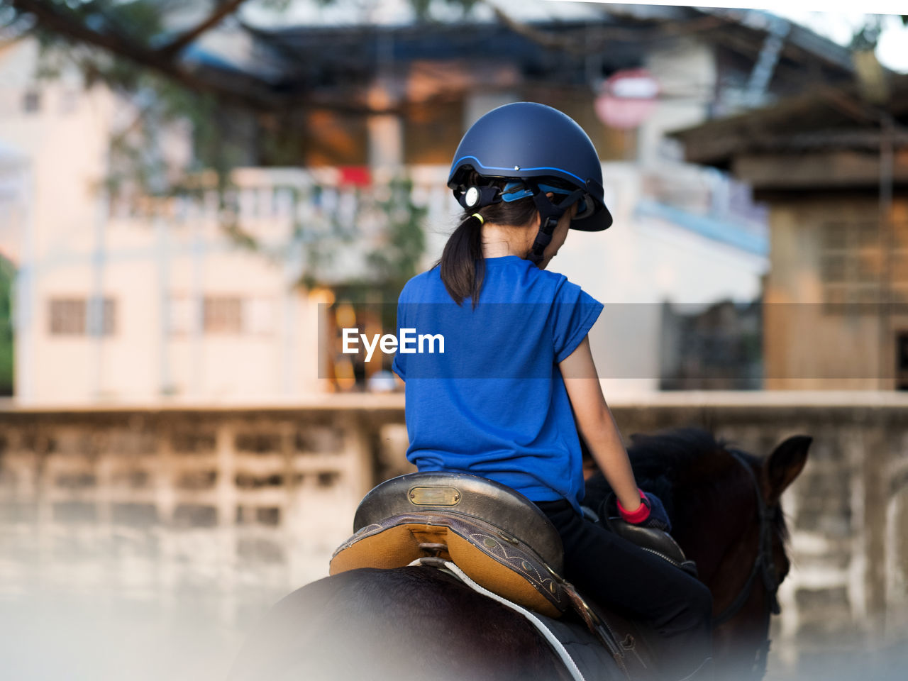 Asian school kid riding horse or practicing horse at horse ranch