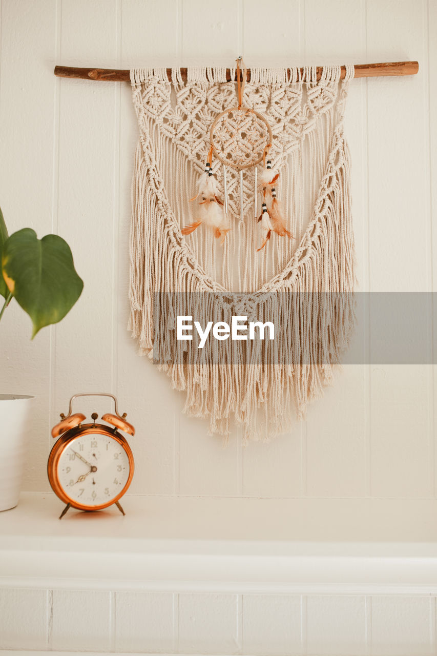Wall macrame with house plants and vintage alarm clock