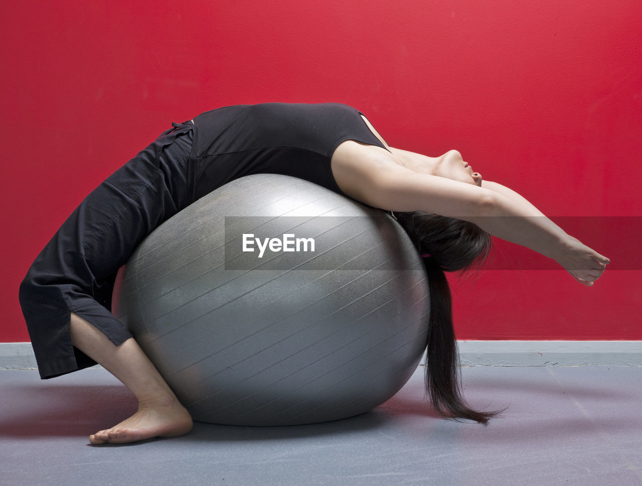 Woman exercising on pilates ball in gym