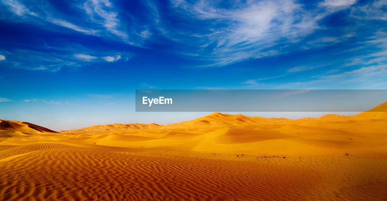 Scenic view of desert against blue sky