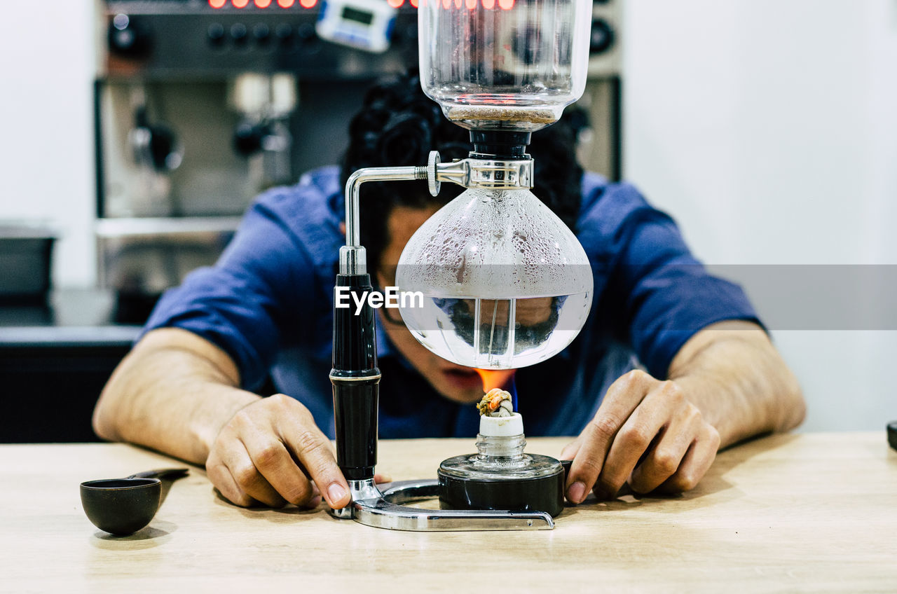 Young man using coffee maker