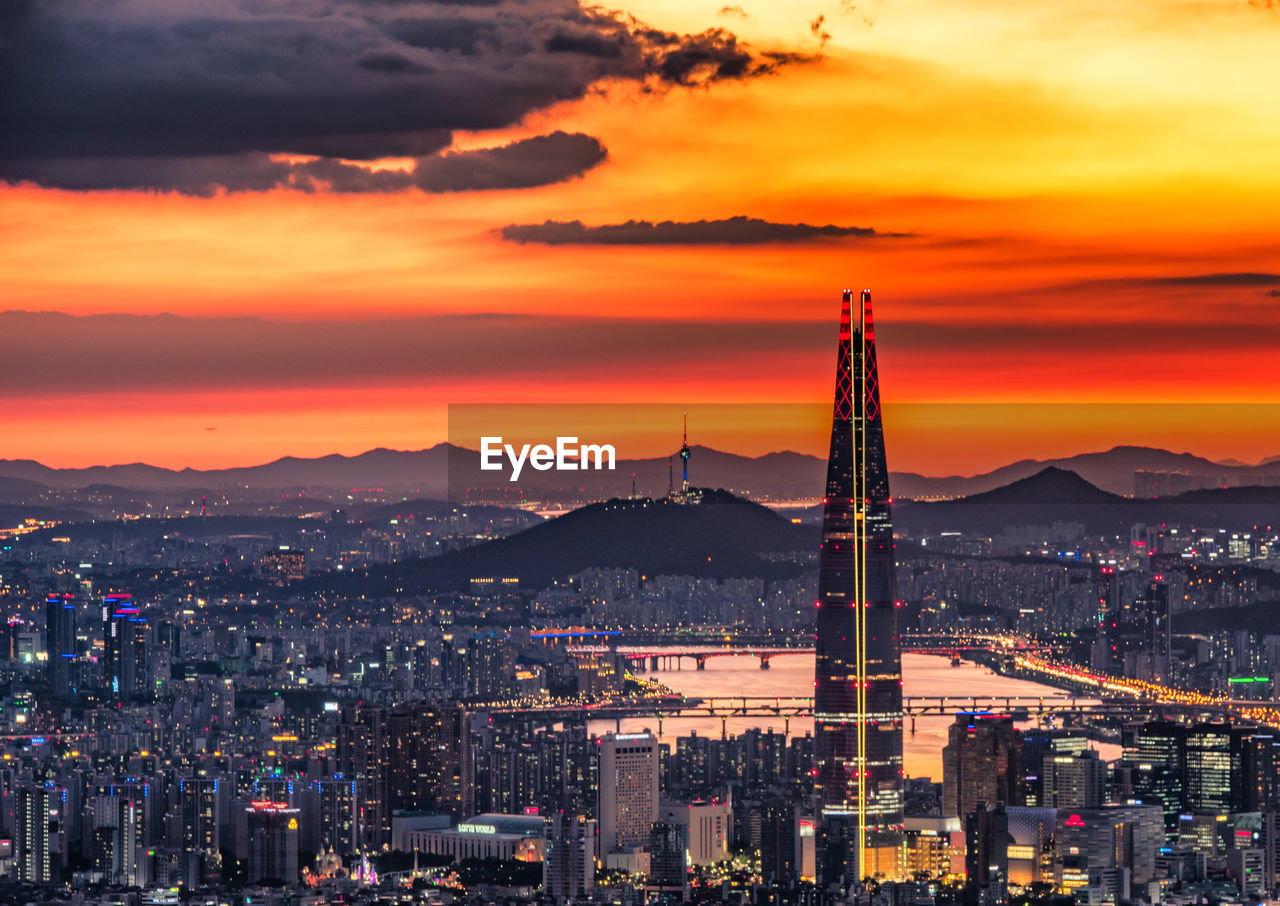 high angle view of illuminated cityscape against sky during sunset