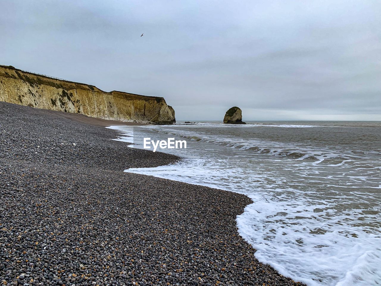 ROCKS ON BEACH AGAINST SKY