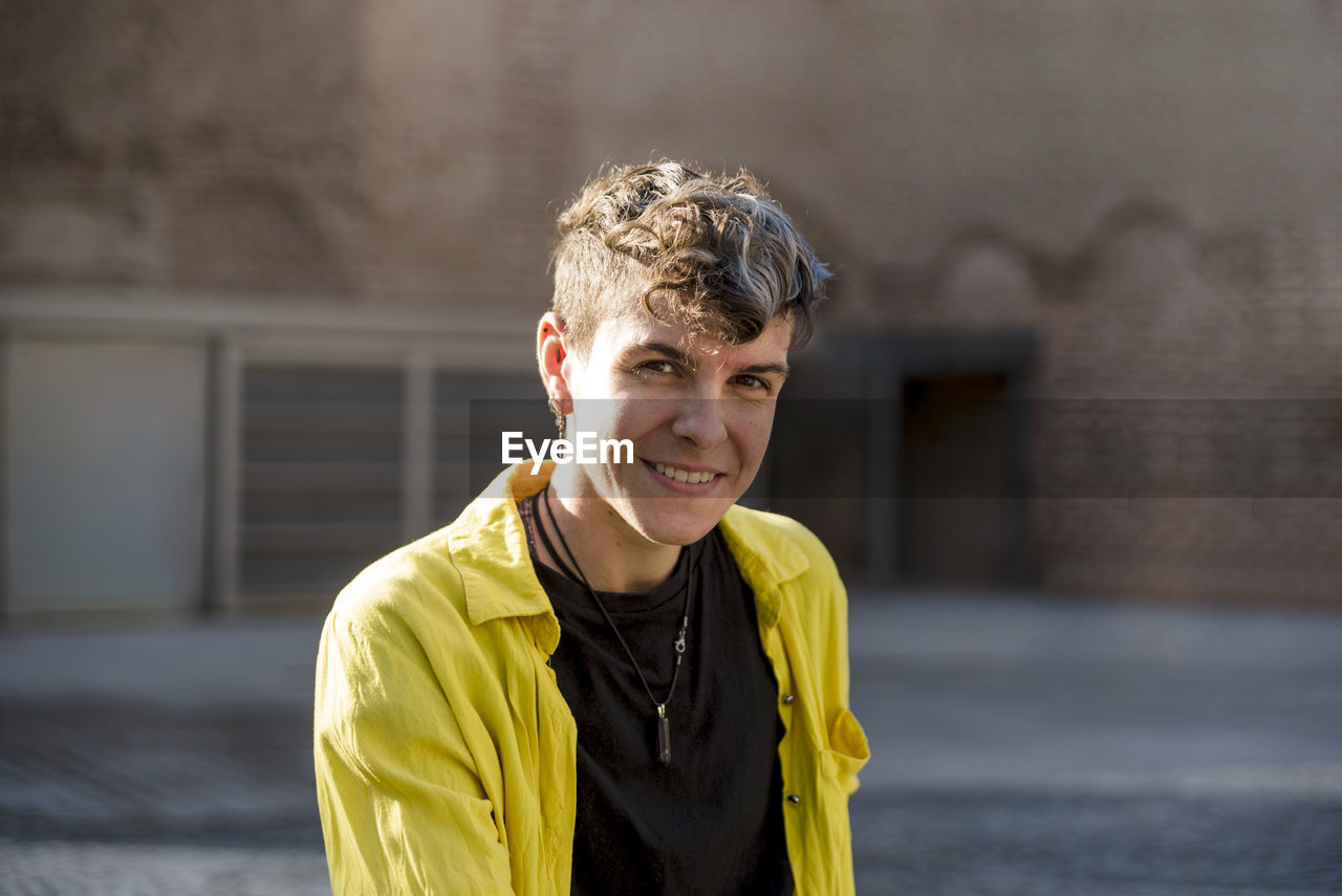 Portrait of a non binary person looking at camera while posing outdoors. person