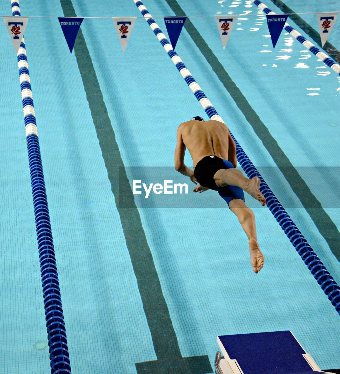 Rear view of man diving into swimming pool