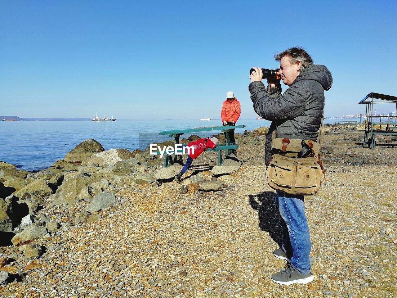 FULL LENGTH OF PHOTOGRAPHER PHOTOGRAPHING SEA