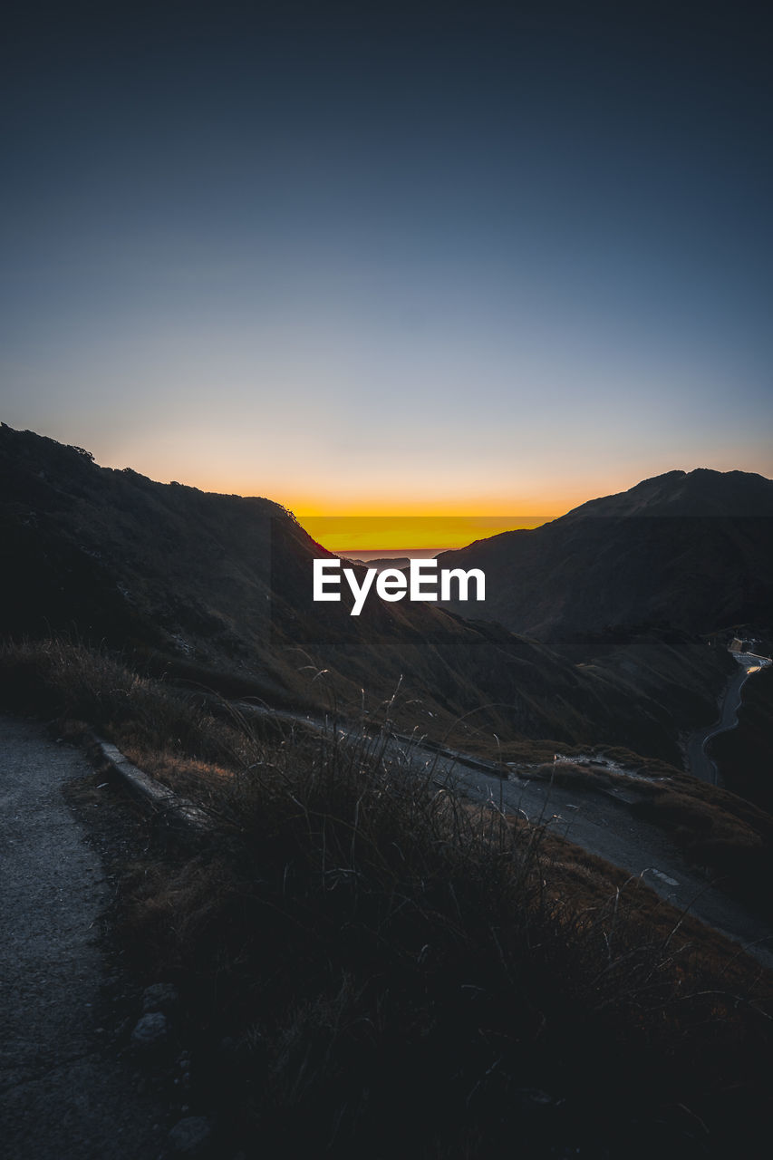 Scenic view of mountains against clear sky during sunset