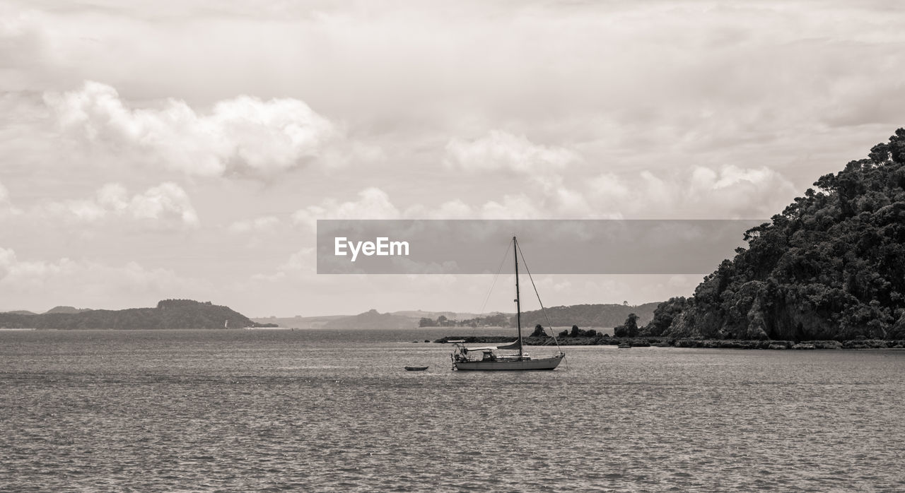 BOATS IN SEA WITH CLOUDY SKY