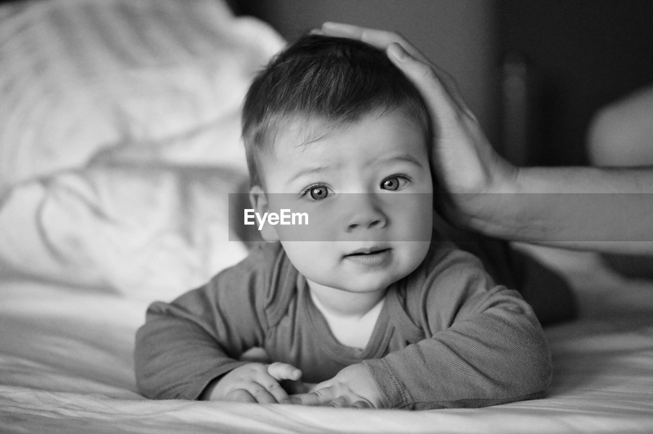 Portrait of cute baby lying on bed