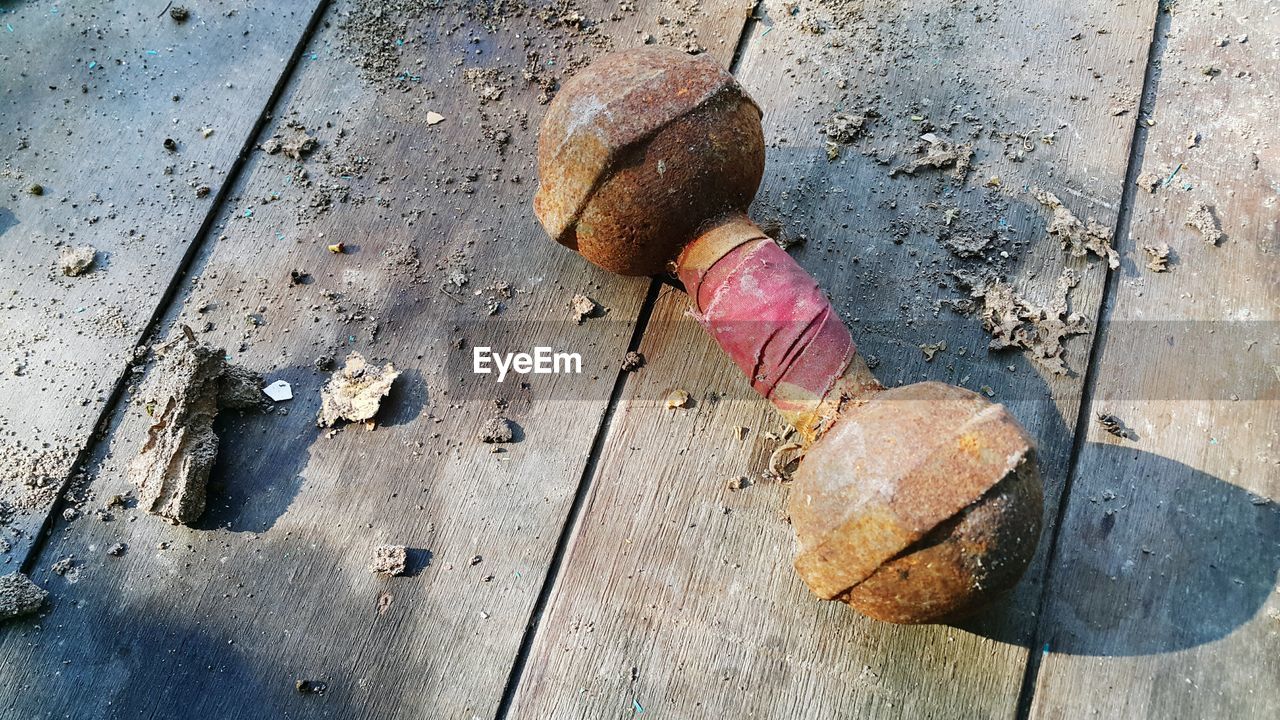 HIGH ANGLE VIEW OF RUSTY CHAIN ON WOOD