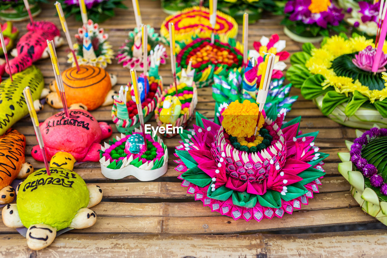 HIGH ANGLE VIEW OF MULTI COLORED FLOWERS IN GLASS ON TABLE