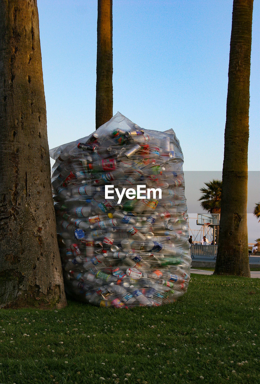 CLOSE-UP OF GARBAGE CAN AGAINST TREES