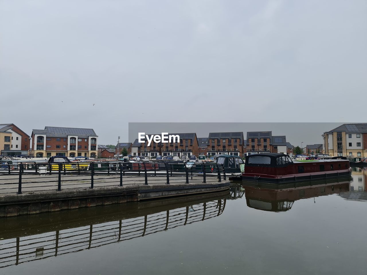 Buildings by river against sky in city