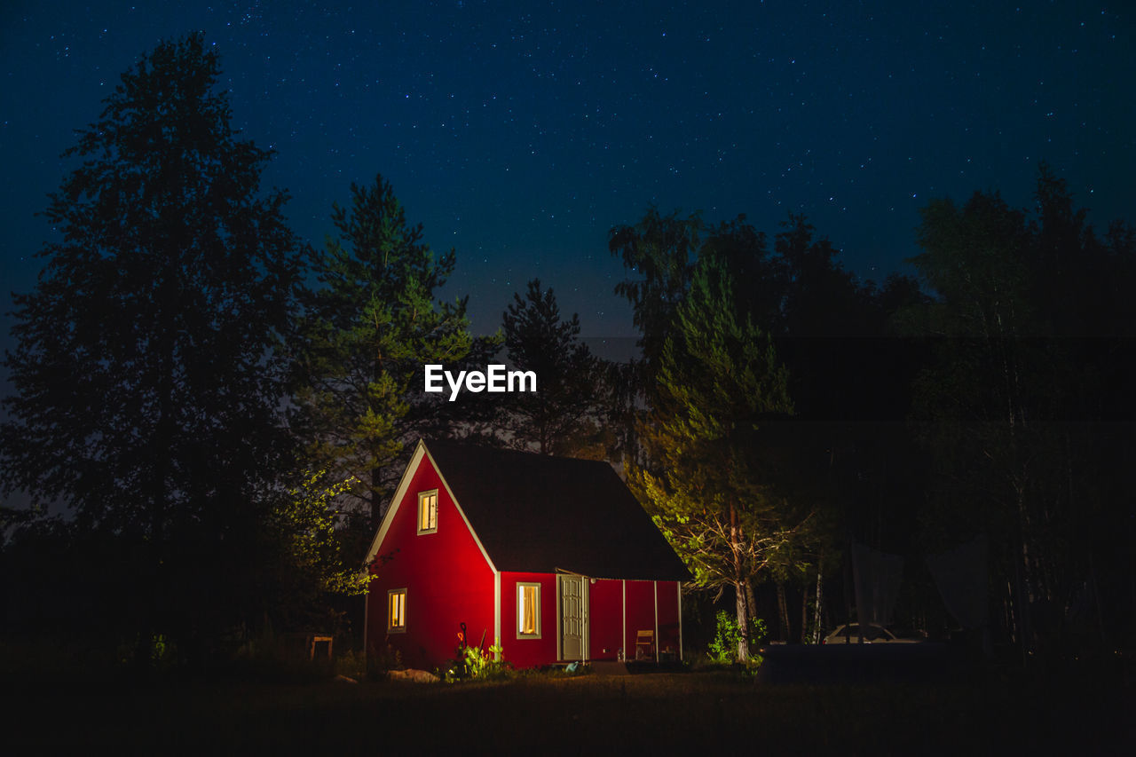 House on field against sky at night