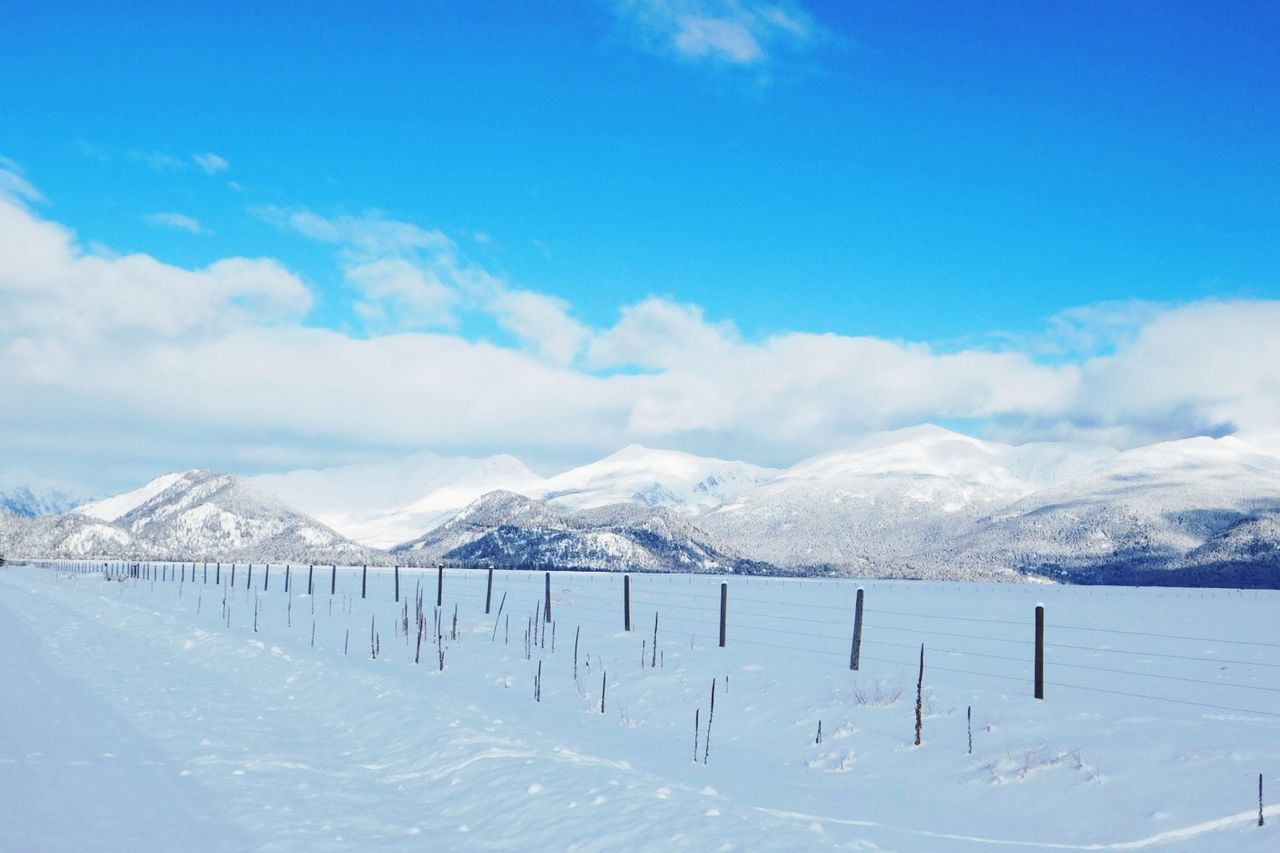 Scenic view of snowcapped mountains against blue sky