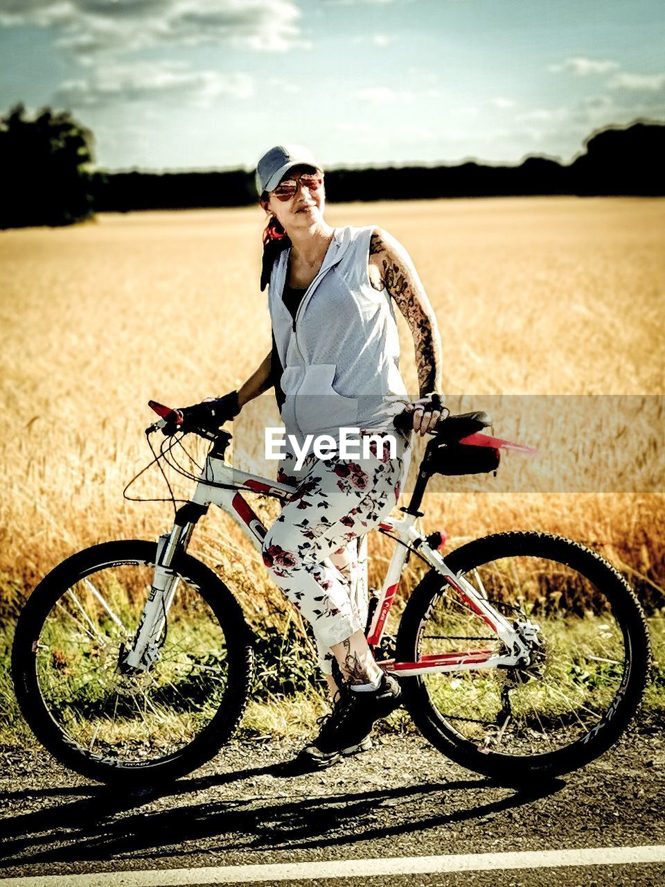 Full length of woman standing with bicycle on field