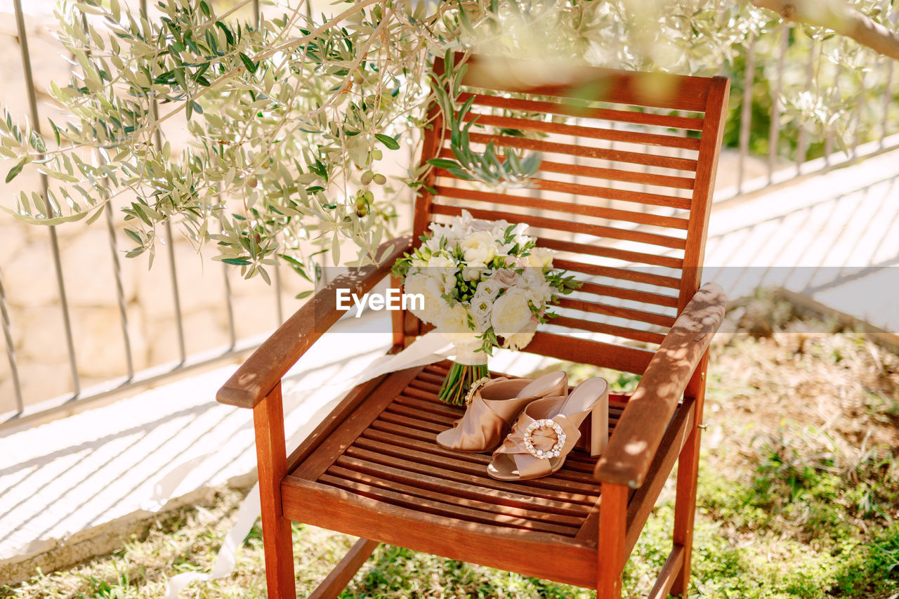 EMPTY CHAIRS AND TABLE BY POTTED PLANTS ON CHAIR