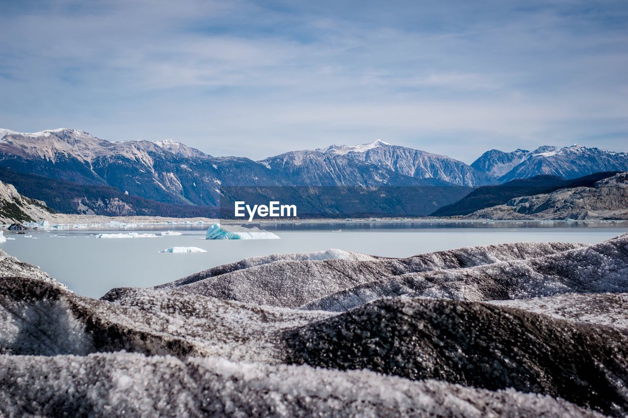 Scenic view of snowcapped mountains by sea against sky