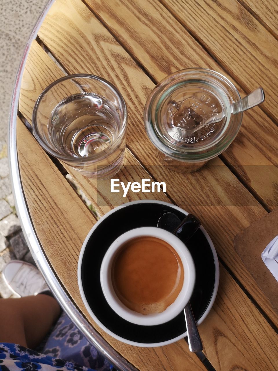 food and drink, drink, refreshment, cup, coffee, mug, high angle view, table, wood, food, indoors, kitchen utensil, coffee cup, crockery, hot drink, spoon, directly above, still life, eating utensil, no people, household equipment, glass, saucer, freshness, drinking glass, tea