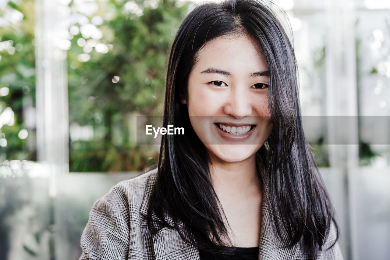 Portrait of happy professional chinese entrepreneur woman in cafeteria. technology, lifestyle