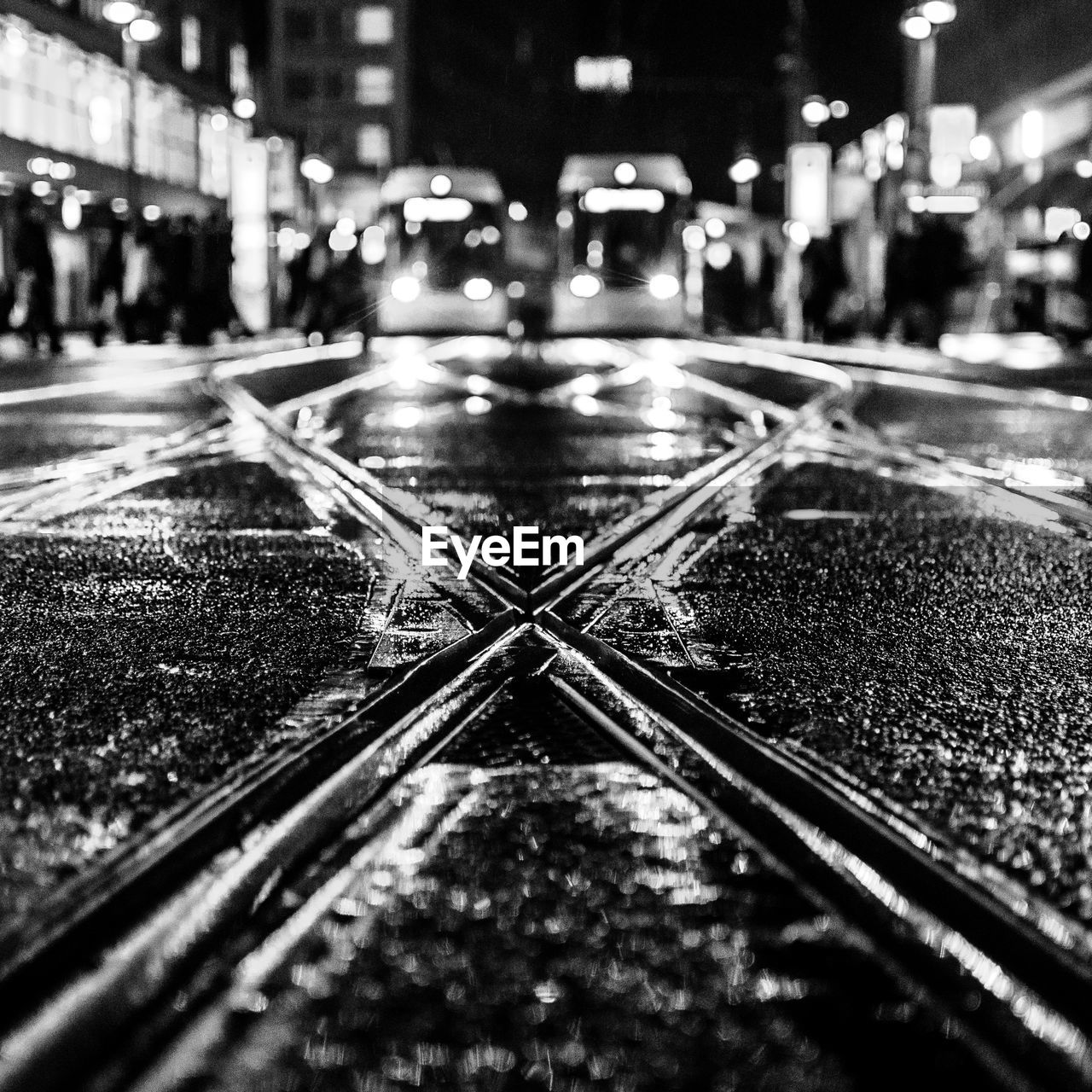 Tramway on wet street in city at night