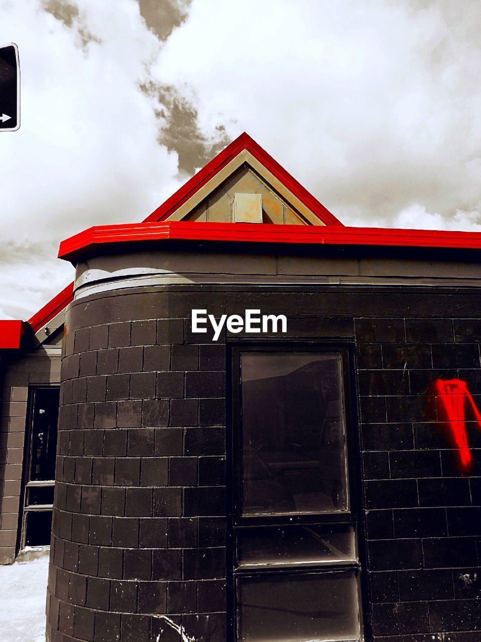 LOW ANGLE VIEW OF RED HOUSE AGAINST CLOUDY SKY