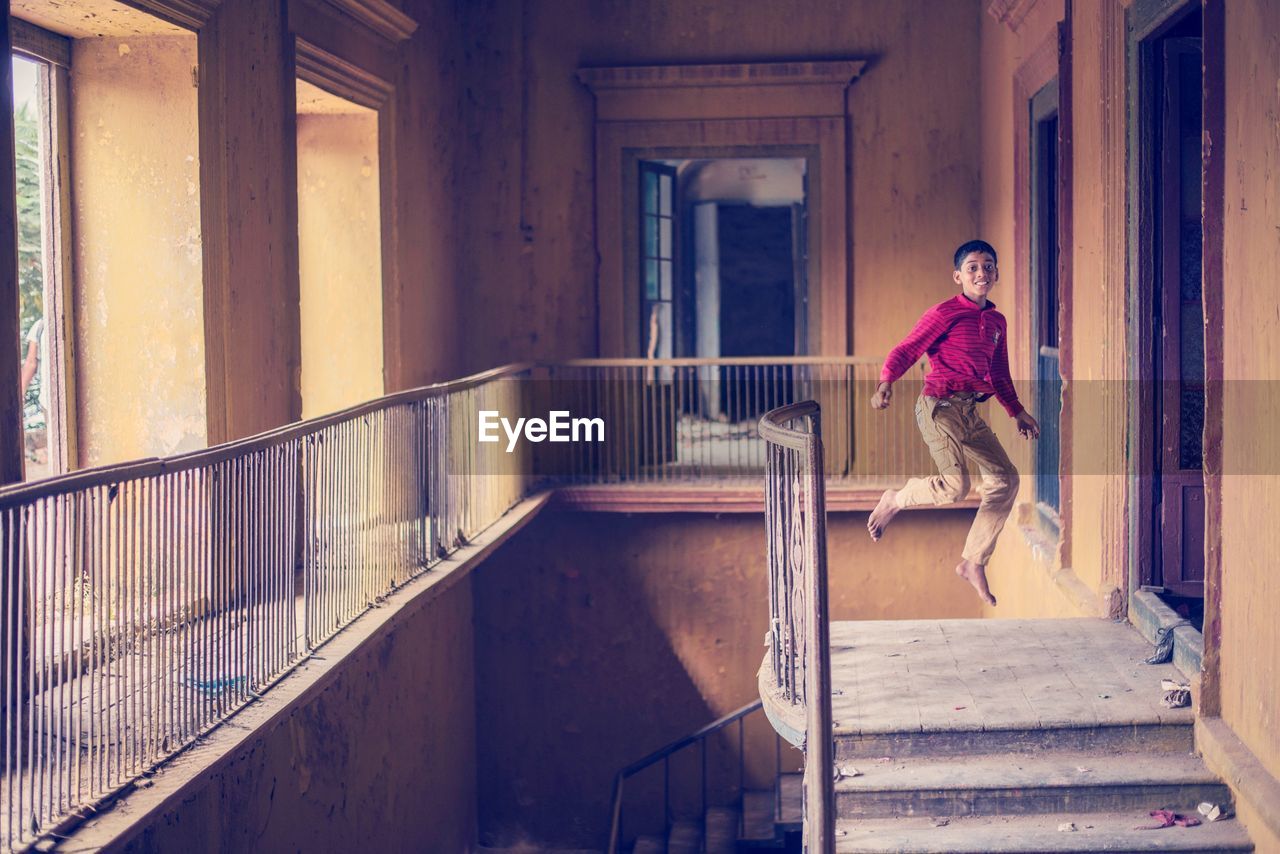 Portrait of teenage boy jumping in abandoned building