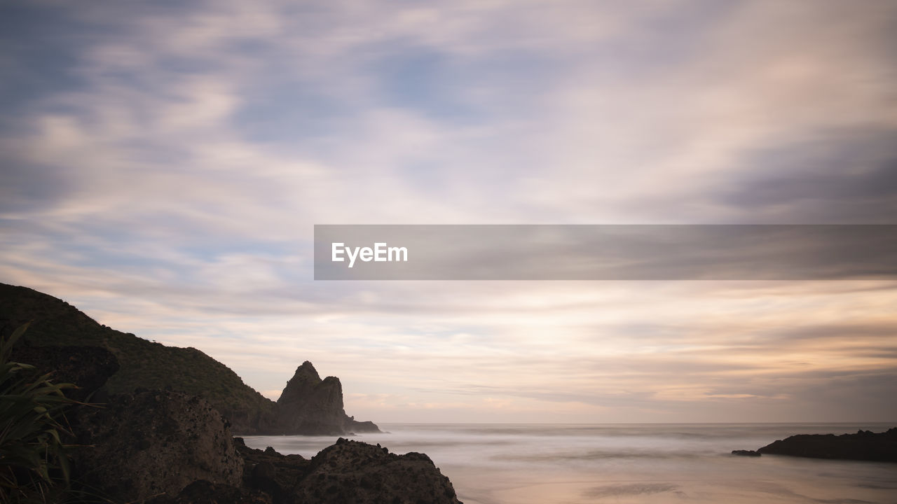 SCENIC VIEW OF ROCKS ON BEACH AGAINST SKY