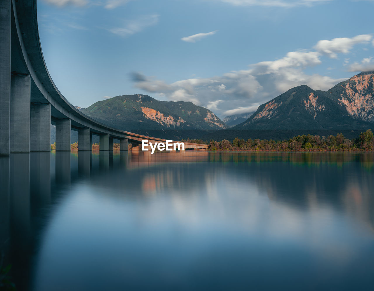 Scenic view of lake with bridge against sky