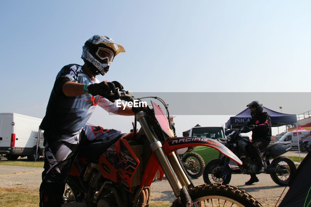 real people, clear sky, land vehicle, outdoors, day, transportation, motorcycle, men, one person, helmet, sky, people