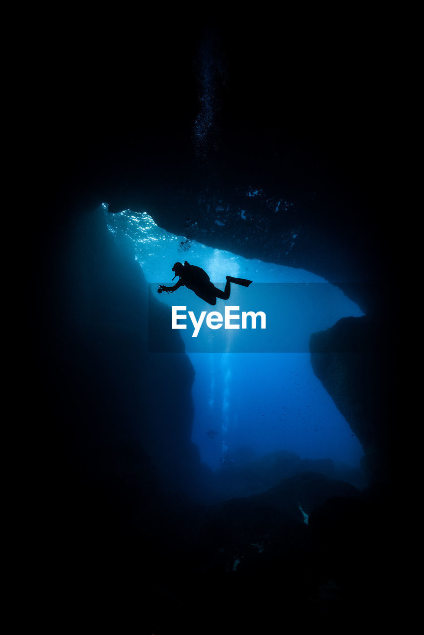 Silhouette of scuba diver in cave