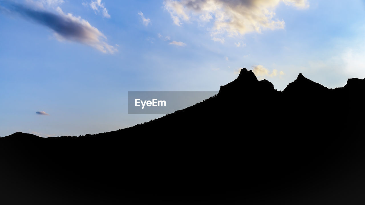 LOW ANGLE VIEW OF SILHOUETTE MOUNTAIN AGAINST SKY