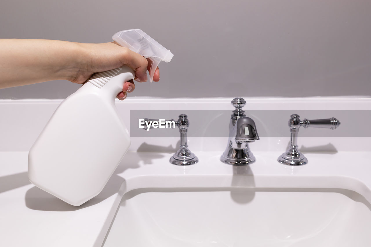 cropped hand of woman washing hands in bathroom