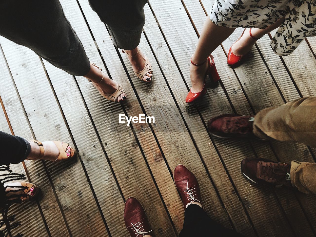 Low section of people standing on hardwood floor