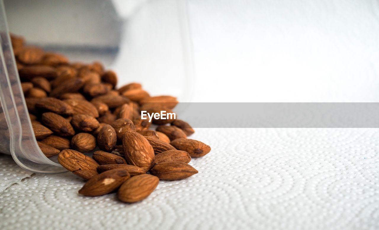 Close-up of almonds spilling on table