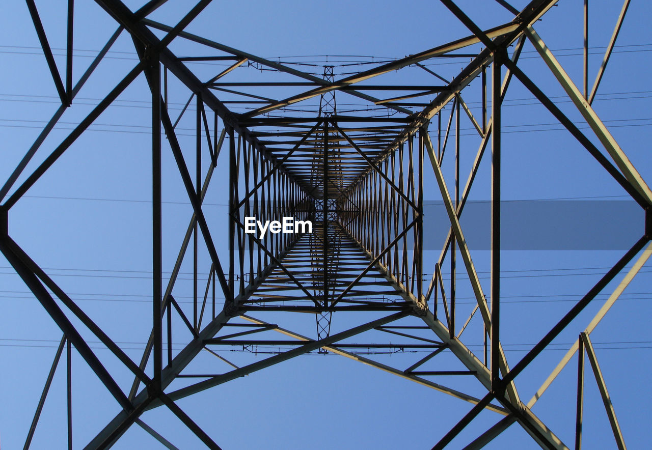 Directly below shot of electricity pylon against clear blue sky