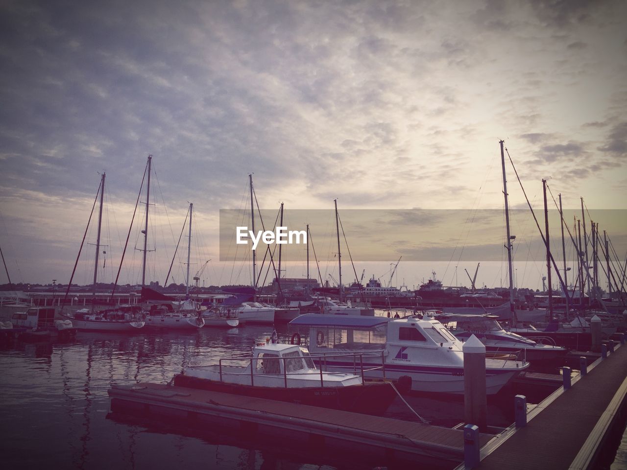 Boats moored at harbor against sky