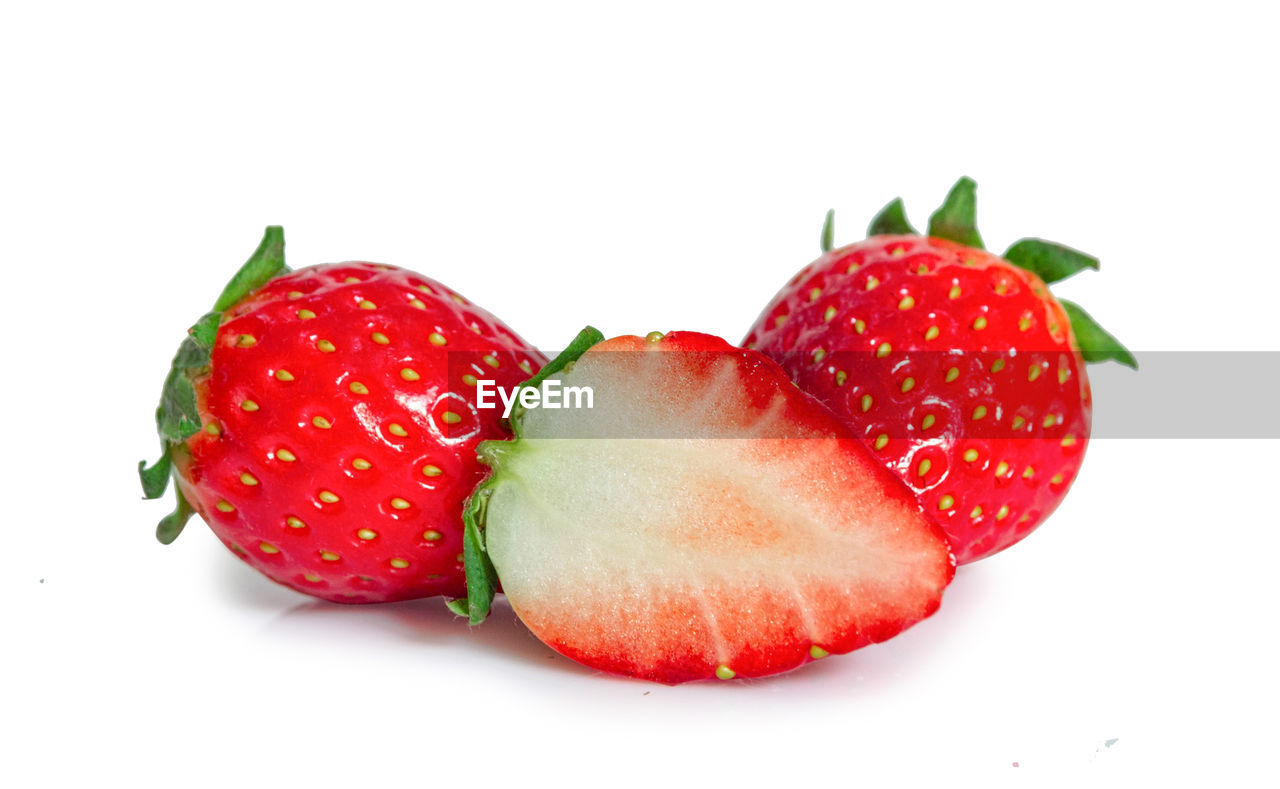 CLOSE-UP OF STRAWBERRIES AGAINST WHITE BACKGROUND