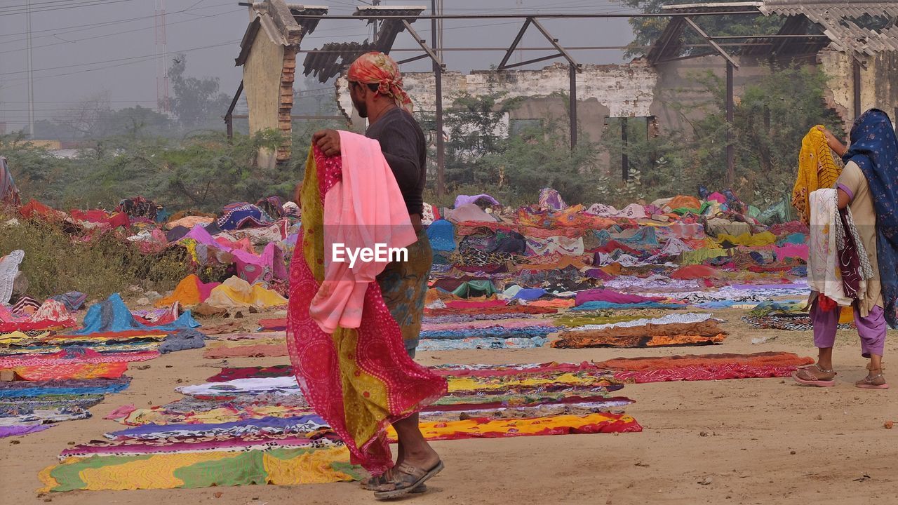 WOMEN STANDING ON MULTI COLORED UMBRELLAS