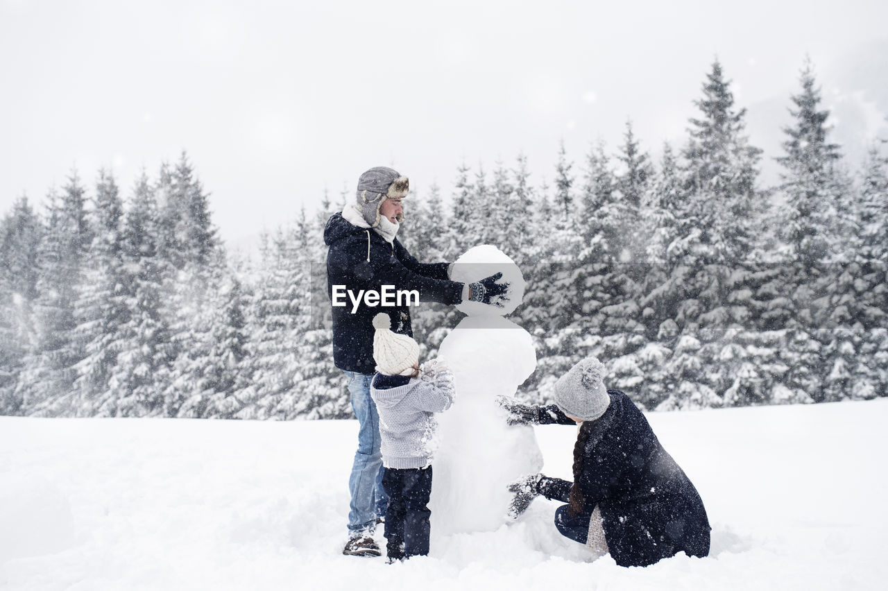 Family building snowman together